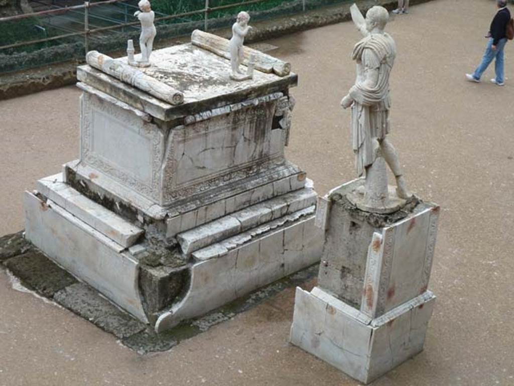 Herculaneum, September 2015. Memorial altar to Marcus Nonius Balbus together with his plaster-cast breast-plated statue, on the right. On the top of the altar stand two marble statues of sleeping funeral figures which would have been leaning on torches, which are now ruined.